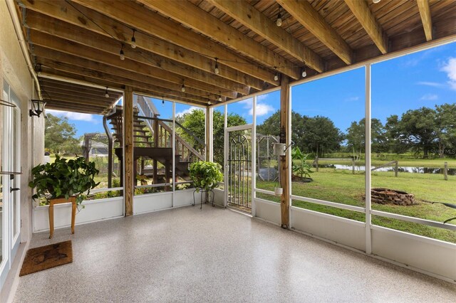 unfurnished sunroom featuring a water view