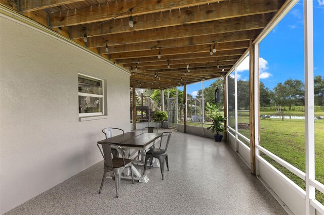 sunroom / solarium featuring a water view