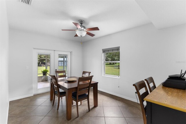 tiled dining space with ceiling fan and french doors