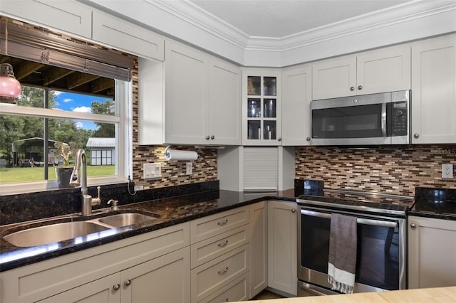 kitchen with ornamental molding, sink, appliances with stainless steel finishes, and tasteful backsplash