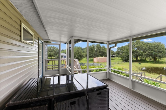 unfurnished sunroom with a water view