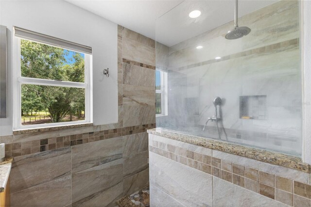 bathroom with tile walls and a tile shower