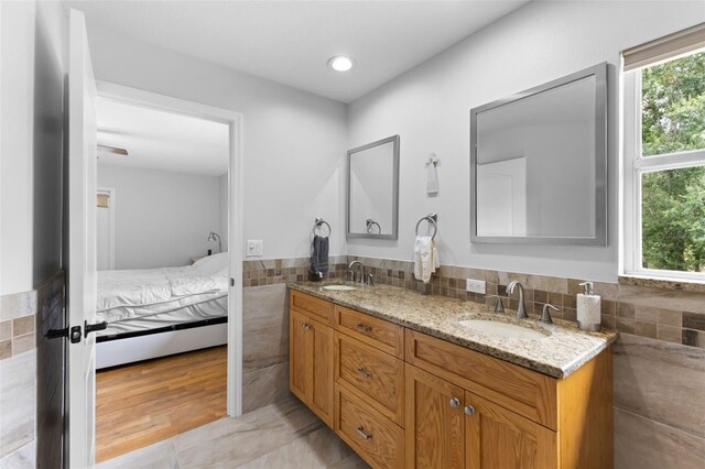 bathroom with vanity, tile walls, wood-type flooring, and decorative backsplash