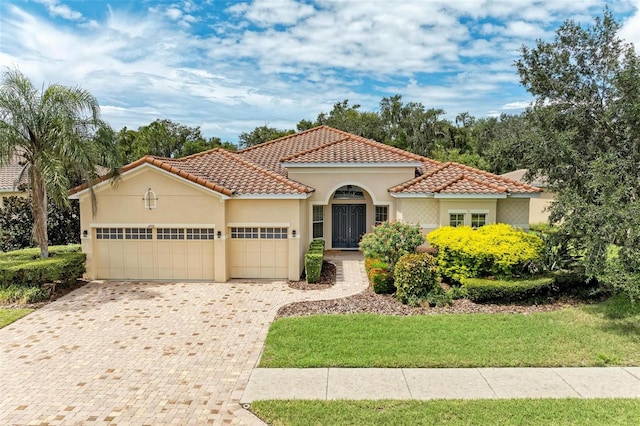 mediterranean / spanish-style home with a front lawn and a garage