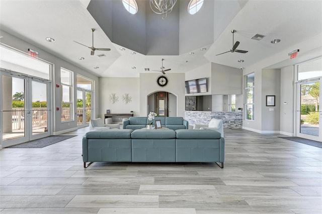 living room with light hardwood / wood-style floors and a towering ceiling