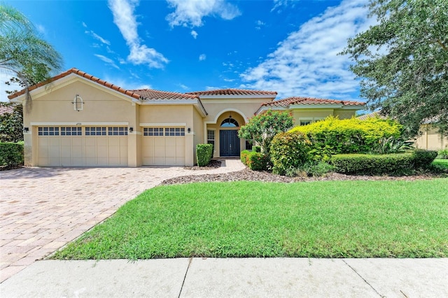 mediterranean / spanish-style house with a garage and a front yard