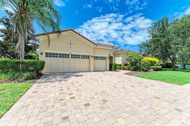 mediterranean / spanish-style house featuring a front lawn and a garage