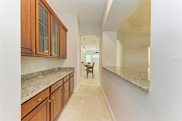 interior space featuring light stone counters and ceiling fan