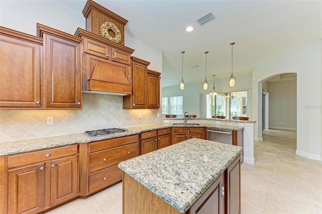 kitchen with decorative backsplash, a center island, stainless steel appliances, and custom exhaust hood