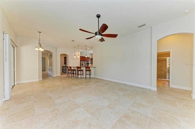 spare room featuring light tile patterned floors and ceiling fan with notable chandelier