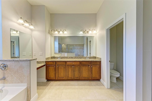 bathroom featuring toilet, vanity, tile patterned floors, and a bathtub