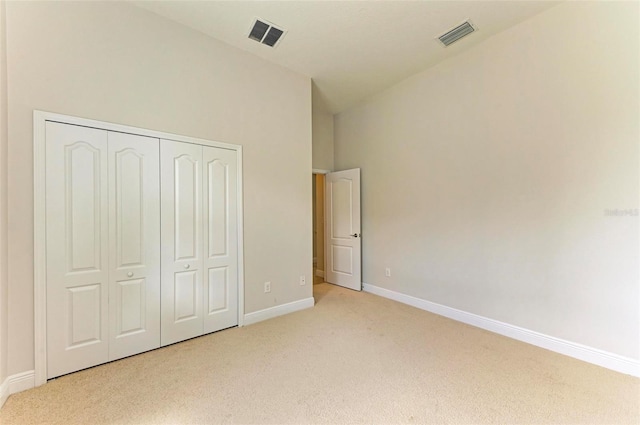 unfurnished bedroom with light carpet and a closet