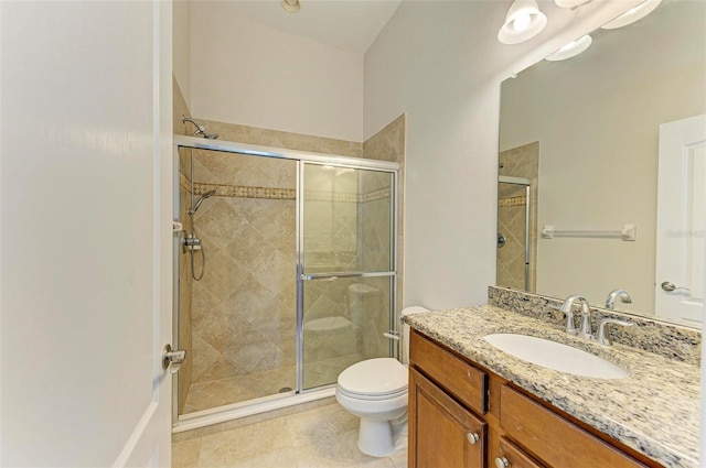 bathroom featuring tile patterned flooring, vanity, toilet, and walk in shower