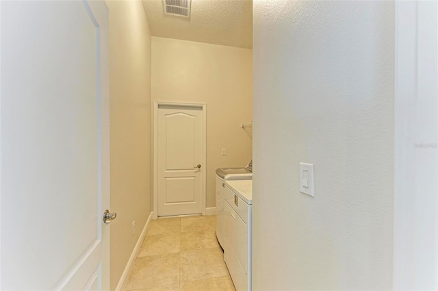 washroom with washing machine and dryer and a textured ceiling