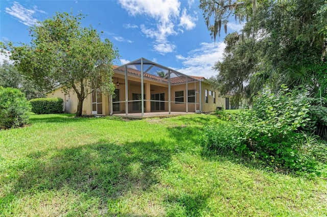 rear view of house featuring a sunroom and a yard