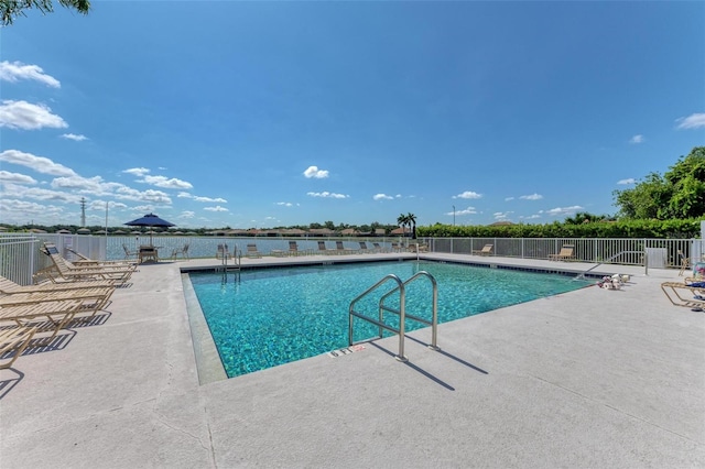 view of pool with a water view and a patio area