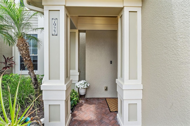 doorway to property featuring stucco siding