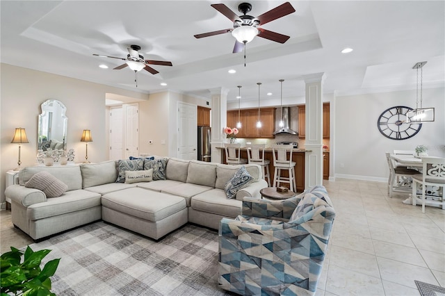 living area with light tile patterned floors, a tray ceiling, decorative columns, and recessed lighting