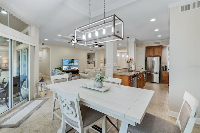 tiled dining area featuring ceiling fan, sink, and ornamental molding