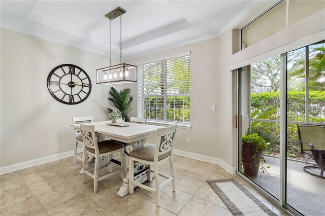 tiled dining area with crown molding, a healthy amount of sunlight, and a tray ceiling