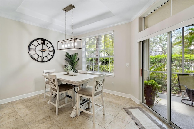 dining area with baseboards, a tray ceiling, and crown molding