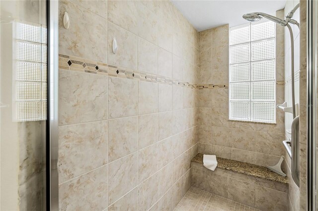 bathroom with plenty of natural light and tiled shower