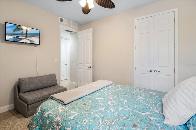 carpeted bedroom with ceiling fan and a closet