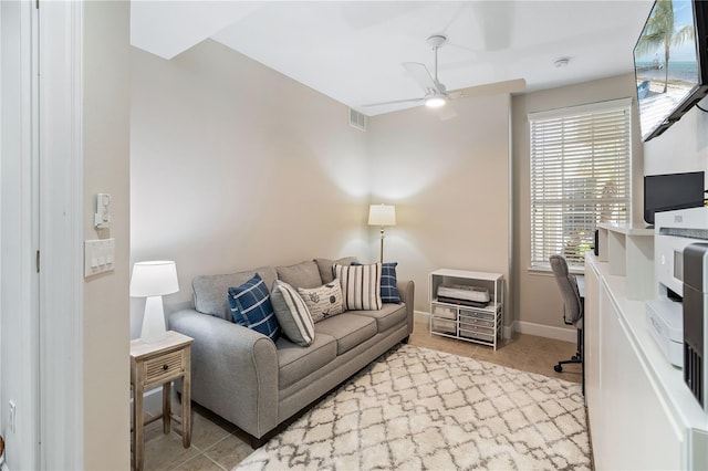 living room with baseboards, tile patterned floors, visible vents, and a ceiling fan