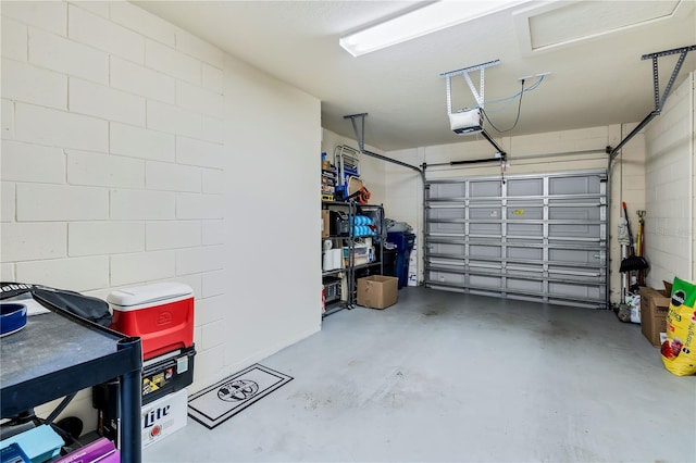 garage featuring a garage door opener and concrete block wall