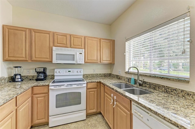 kitchen with white appliances, light stone counters, light tile patterned flooring, and sink