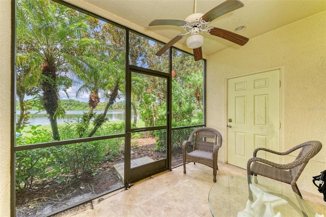 unfurnished sunroom with a water view, ceiling fan, and a wealth of natural light