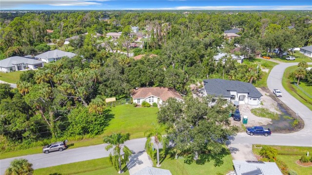 drone / aerial view featuring a residential view and a wooded view