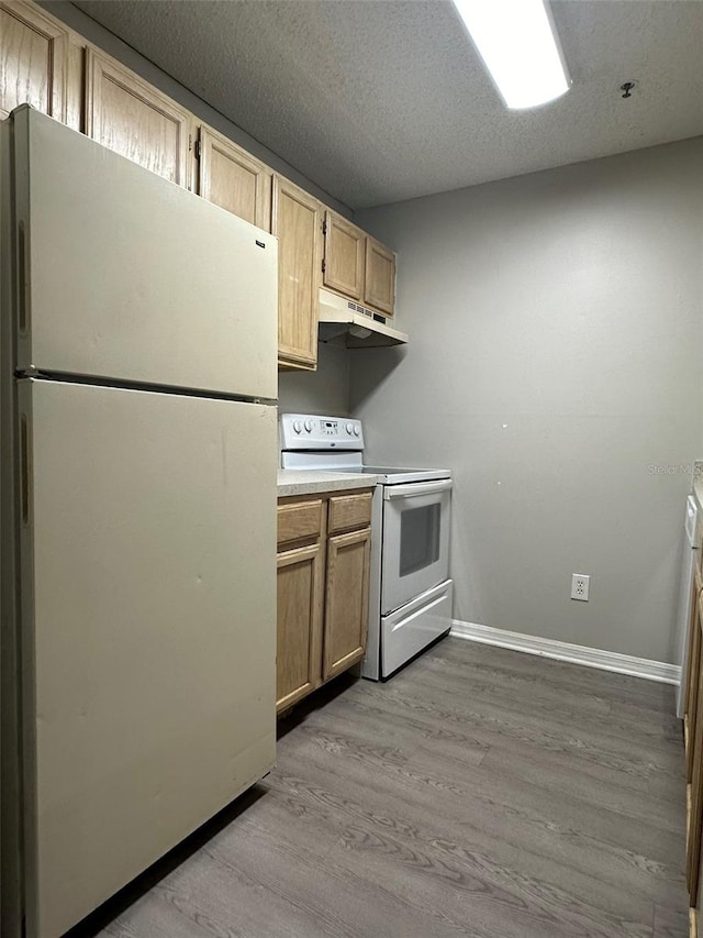 kitchen with light wood-type flooring, white appliances, light brown cabinetry, and a textured ceiling