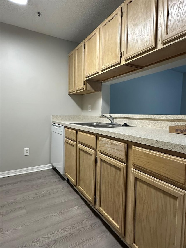 kitchen featuring a textured ceiling, dishwasher, light brown cabinetry, hardwood / wood-style floors, and sink