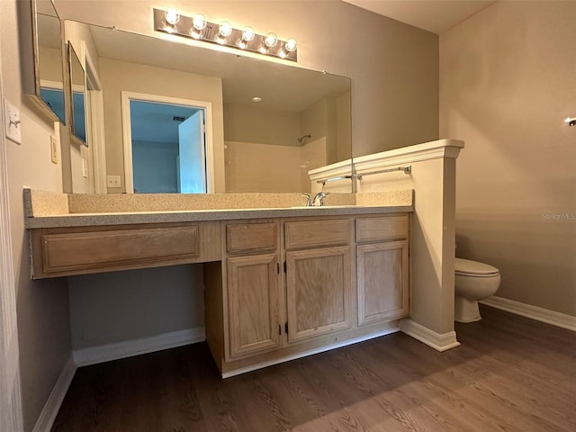 bathroom with hardwood / wood-style floors, toilet, and vanity