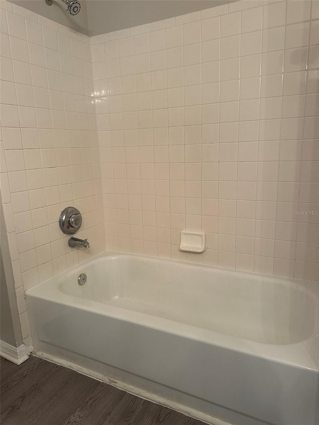 bathroom with tiled shower / bath and wood-type flooring