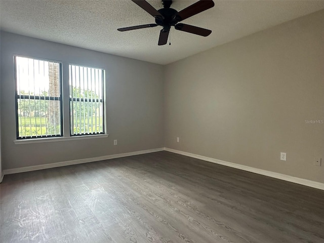 empty room with ceiling fan, dark hardwood / wood-style floors, and a textured ceiling