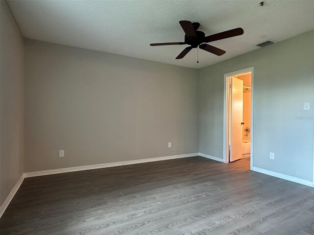 empty room with ceiling fan, hardwood / wood-style flooring, and a textured ceiling