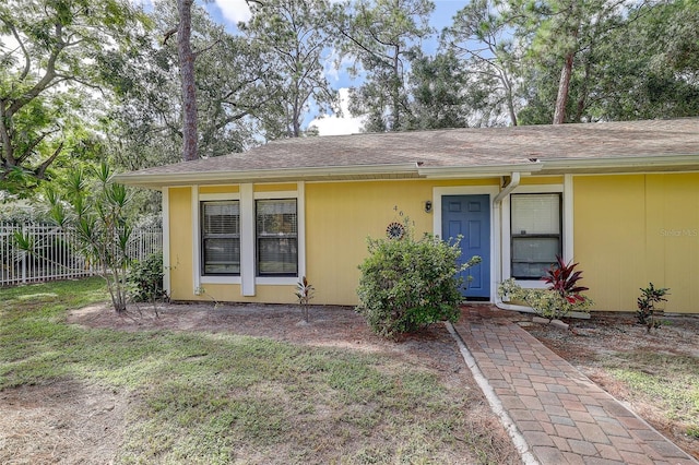 view of front of property with fence and a front lawn