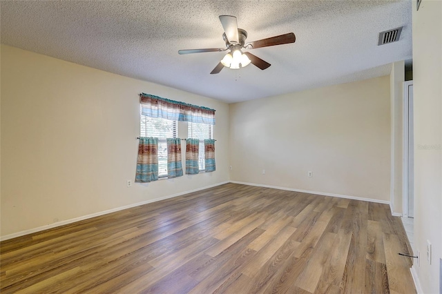 unfurnished room with ceiling fan, wood-type flooring, and a textured ceiling