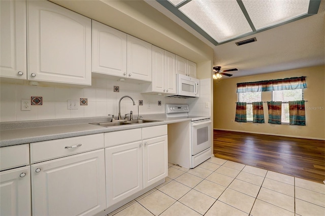 kitchen featuring white appliances, ceiling fan, sink, light tile patterned floors, and white cabinets