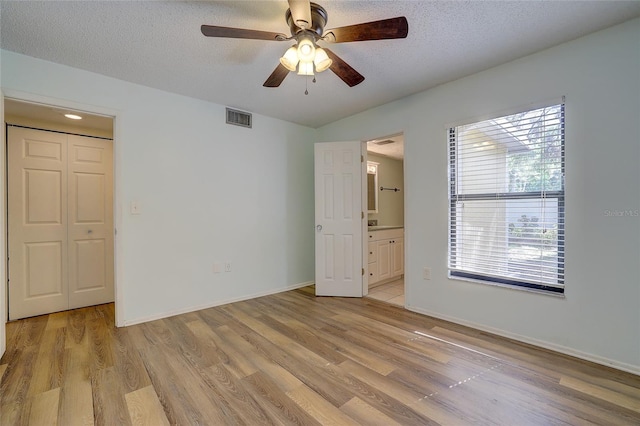 unfurnished room featuring ceiling fan, light hardwood / wood-style floors, and a textured ceiling