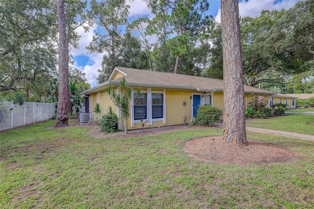 view of front of house with a front yard, central AC, and fence