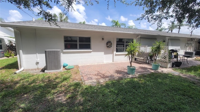 back of house featuring a lawn, a patio, and central AC