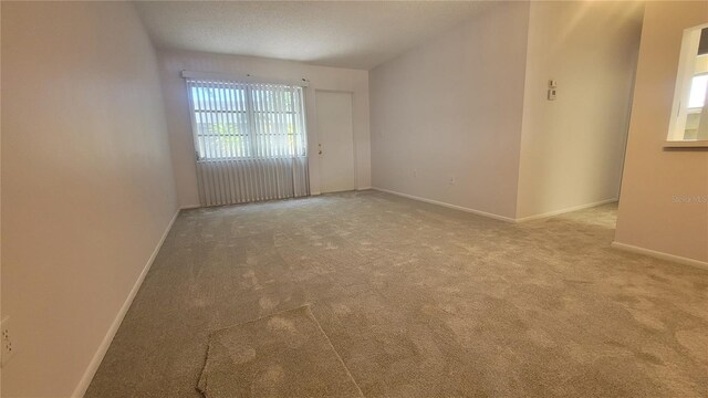 carpeted spare room with a textured ceiling