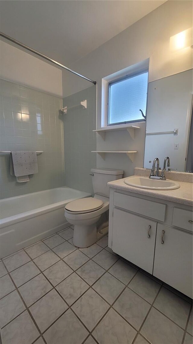 full bathroom with tile patterned flooring, toilet, tiled shower / bath combo, and vanity