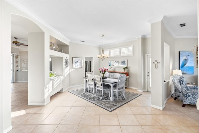 tiled dining room featuring ceiling fan with notable chandelier and ornamental molding