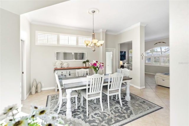 tiled dining area featuring ornamental molding and an inviting chandelier