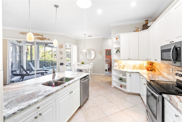 kitchen with light tile patterned floors, appliances with stainless steel finishes, white cabinetry, sink, and pendant lighting