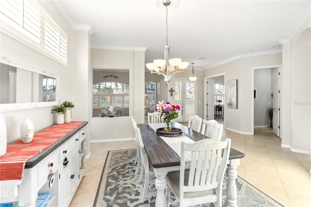 dining area featuring a wealth of natural light, ornamental molding, a notable chandelier, and light tile patterned flooring